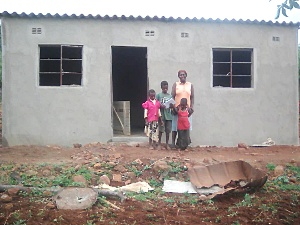 Familie vor verwüstetem Haus wegen Tropensturm Idai